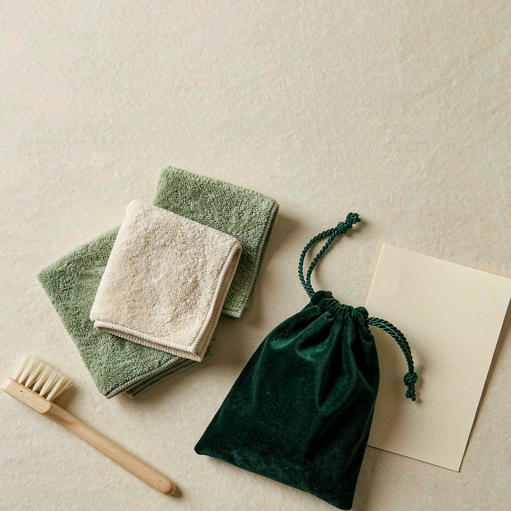The Dry Care Kit laid out: three microfiber cloths, a detail brush, a velvet pouch and a care card